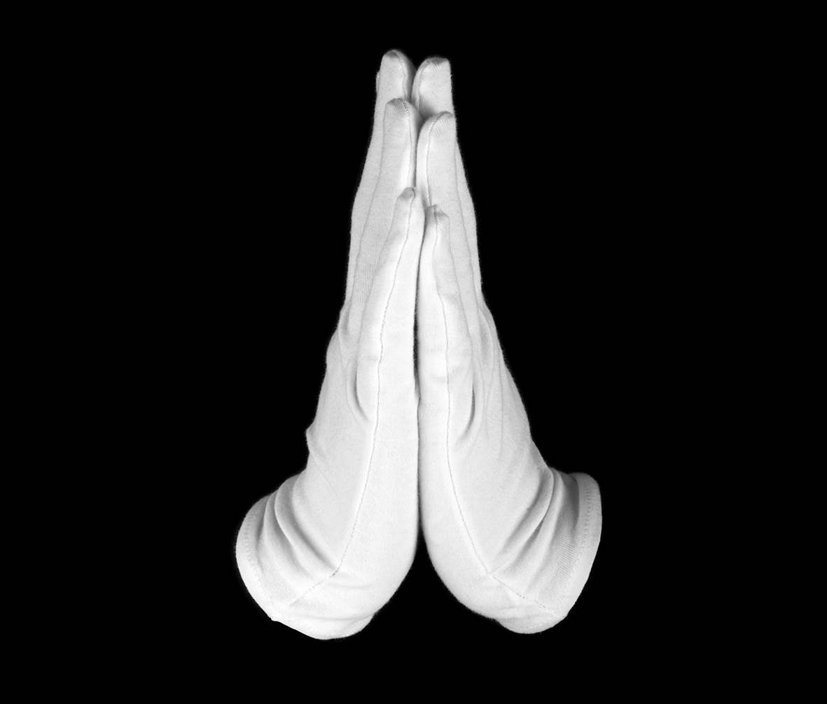 Cleaning: a pair of white gloved hands in prayer against a black background