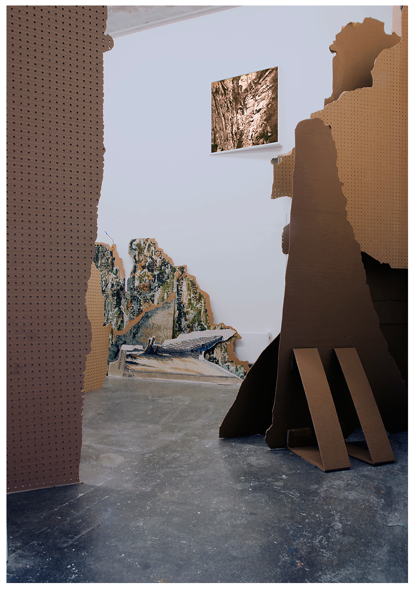 Monumental fragments of landscape stand in a room.