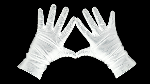 Gaga: Against a black background, white gloved hands splayed out with thumbs and forefingers touching to make a triangle