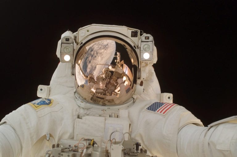 The Case of the Gold Ring: an astronaut with a gold visor looks at the camera against the blackness of space