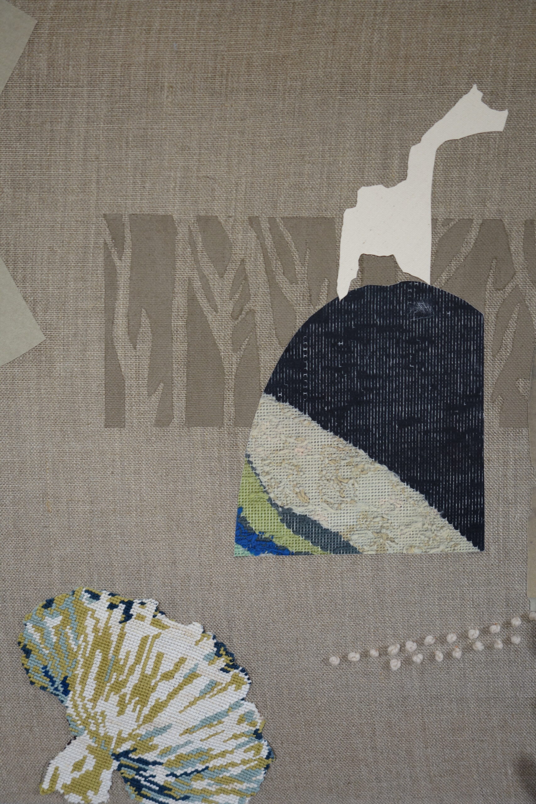 fragments of tapestry, collage and embroidery in the shape of statues and organic forms are scattered across a pale grey-brown linen