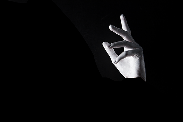The kiss: a single left hand floats against a black background